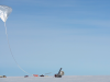 Tethered by a long cable, the high altitude balloon carrying the GUSTO telescope is being launched from McMurdo Research Station in Antarctica.